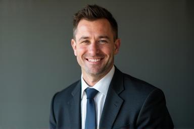 Professional and confident corporate headshot of a man in a business setting